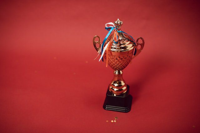 MKYF A gold trophy on a red background, awarded to the basketball league champions.