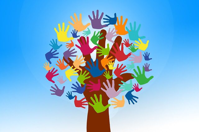MKYF The Kingdom Cares Community Service Event showcases a majestic tree adorned with numerous colorful hands, symbolizing unity and compassion towards others.
