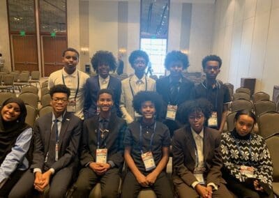 MKYF Group of students at a conference event, wearing formal attire and name tags.