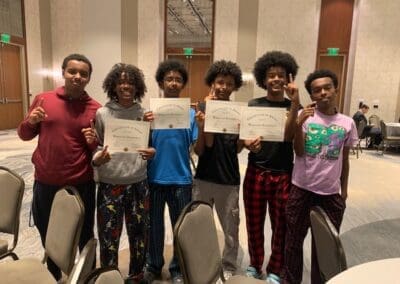 MKYF A group of young individuals proudly displaying their certificates of achievement.