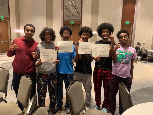 MKYF A group of young individuals proudly displaying their certificates of achievement.