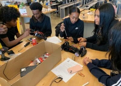 MKYF Students engaged in assembling and discussing robotic projects.