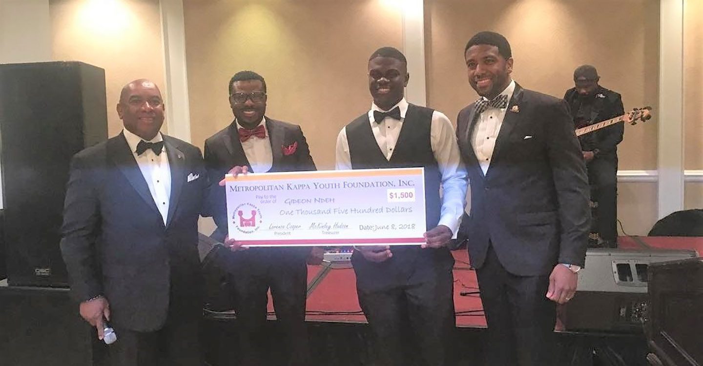 Four gentlemen holding enlarged scholarship check